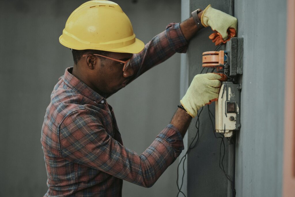 A photo of an electrician working on solving an electrical issue in a home, with a text that says “Myslots Scheduling Software - The best online booking and payment system for home repair specialists