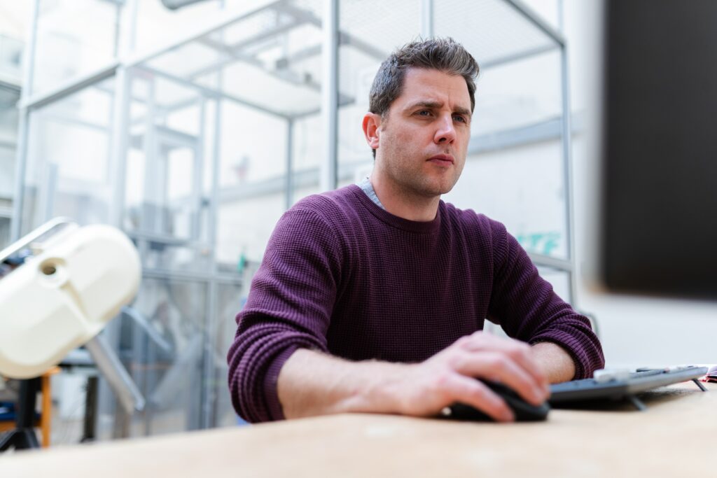 A photo of an engineer sitting on his laptop and looking at his business reports for his home repair services that he booked online using Myslots Scheduling Software